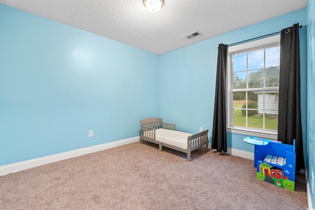 unfurnished bedroom featuring multiple windows, carpet flooring, and a textured ceiling