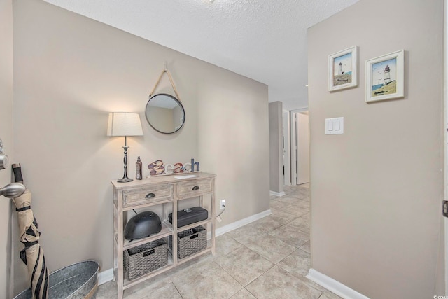 hallway featuring a textured ceiling and light tile patterned floors