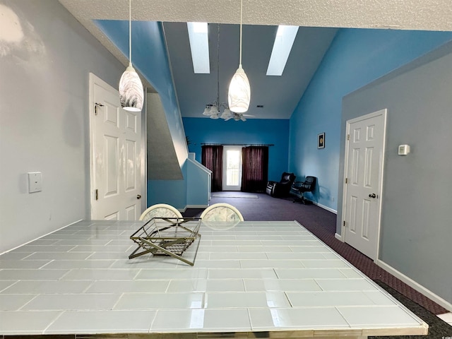 interior space featuring a textured ceiling and lofted ceiling with skylight