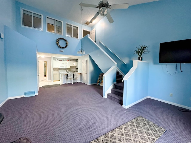 misc room featuring carpet flooring, a high ceiling, and ceiling fan