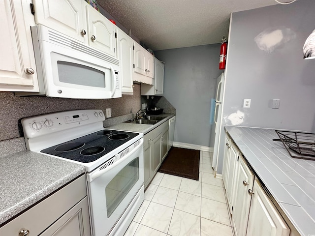 kitchen featuring white cabinets, white appliances, tile countertops, and sink