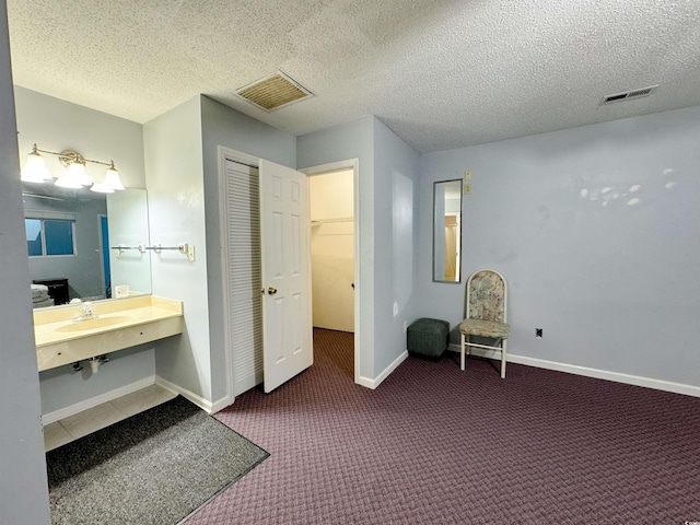 bathroom with a textured ceiling and sink