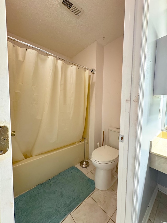 bathroom featuring toilet, shower / bath combo, a textured ceiling, and tile patterned floors