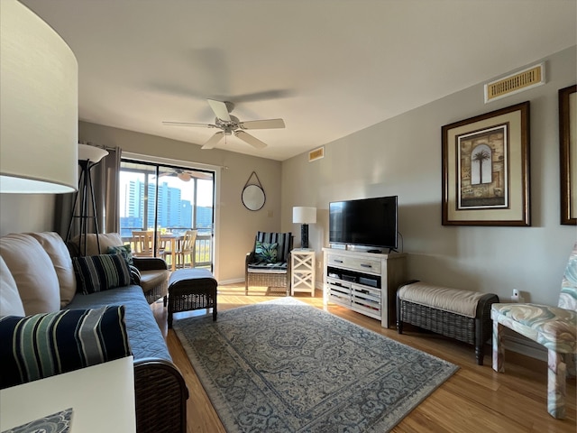 living room featuring hardwood / wood-style floors and ceiling fan