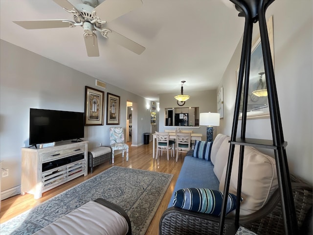 living room featuring hardwood / wood-style floors and ceiling fan