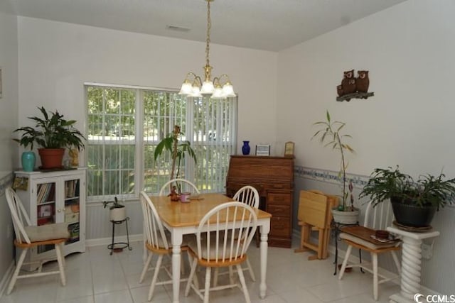 tiled dining space featuring a notable chandelier