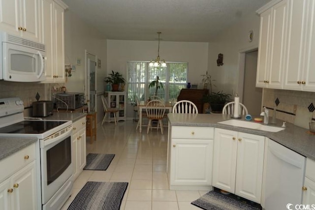 kitchen featuring white cabinetry, sink, hanging light fixtures, and white appliances