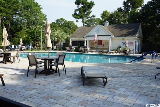 view of swimming pool with a patio and an outbuilding