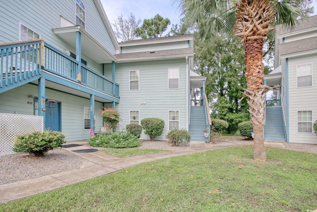 exterior space featuring a balcony and a front yard