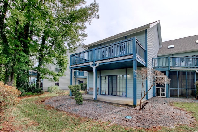 rear view of property featuring a patio and a balcony