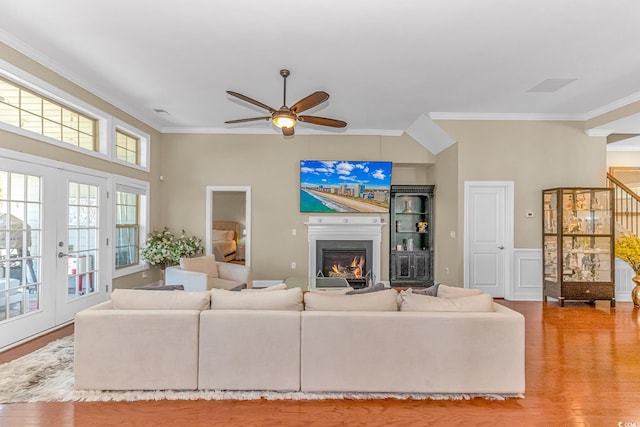 living room with ceiling fan, ornamental molding, and light wood-type flooring