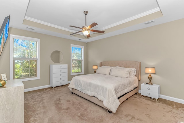 carpeted bedroom featuring ornamental molding, a tray ceiling, and ceiling fan