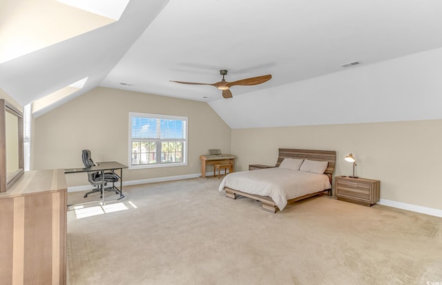 carpeted bedroom featuring lofted ceiling with skylight and ceiling fan