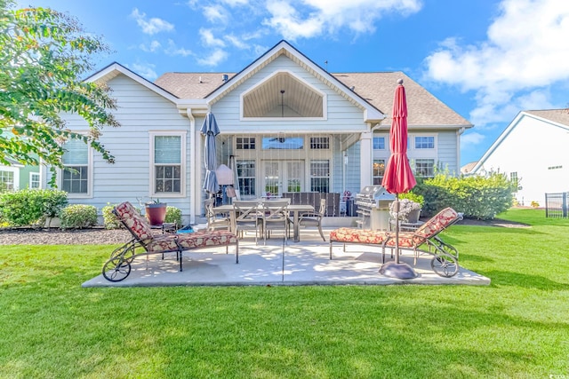 back of property with a yard and a patio