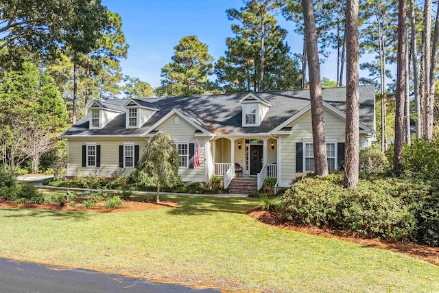 cape cod house with covered porch and a front lawn