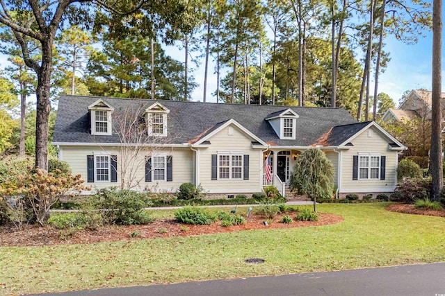 cape cod home featuring a front yard