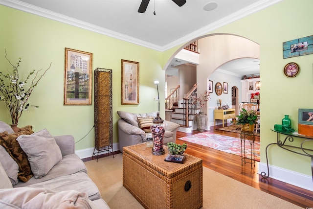 living room with ceiling fan, light wood-type flooring, and ornamental molding