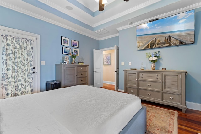 bedroom with dark wood-type flooring, a raised ceiling, ceiling fan, and crown molding