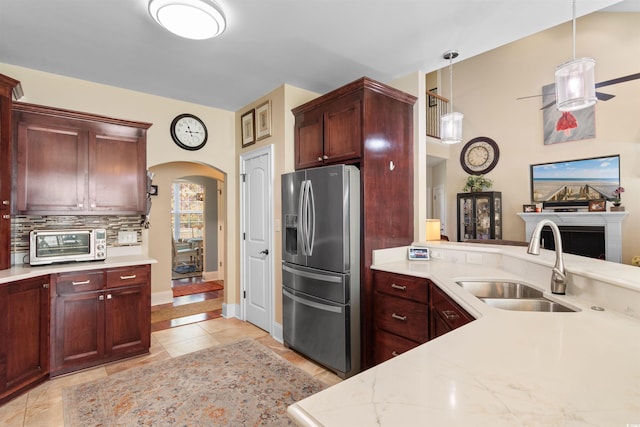 kitchen with sink, light tile patterned floors, backsplash, stainless steel fridge, and pendant lighting