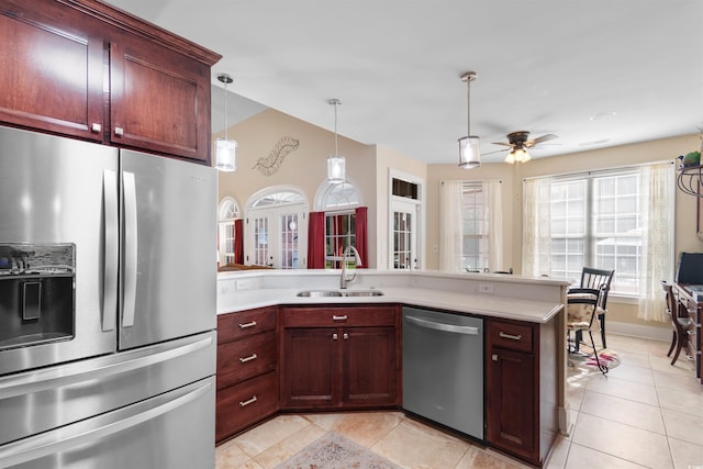 kitchen with appliances with stainless steel finishes, decorative light fixtures, light tile patterned floors, sink, and ceiling fan