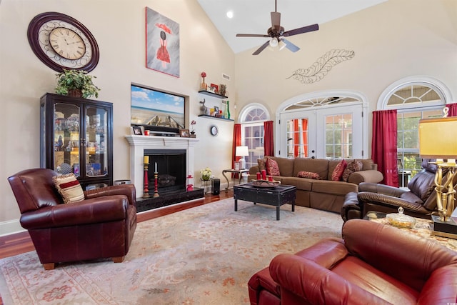 living room featuring french doors, wood-type flooring, a fireplace, high vaulted ceiling, and ceiling fan