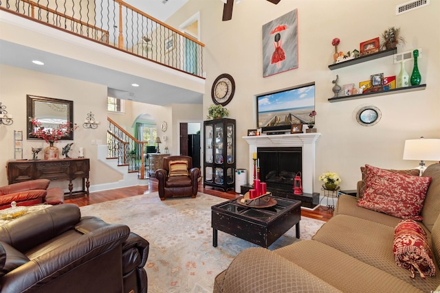 living room with light hardwood / wood-style floors and a towering ceiling