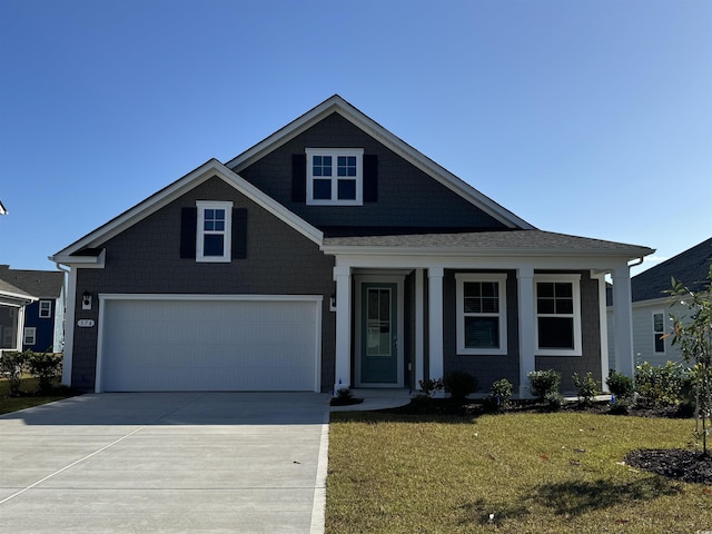 craftsman house with a garage and a front lawn