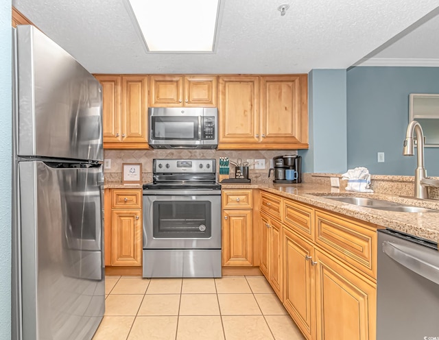 kitchen featuring sink, stainless steel appliances, crown molding, decorative backsplash, and light tile patterned flooring