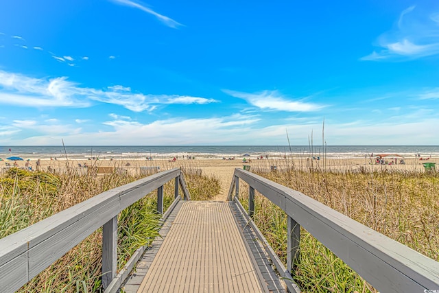 view of property's community featuring a beach view and a water view