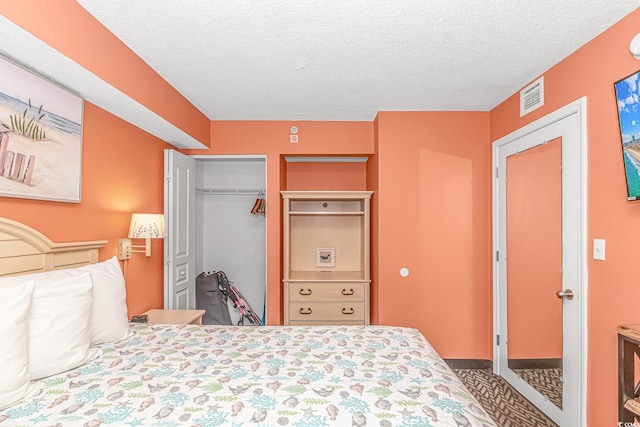 bedroom with a textured ceiling and a closet