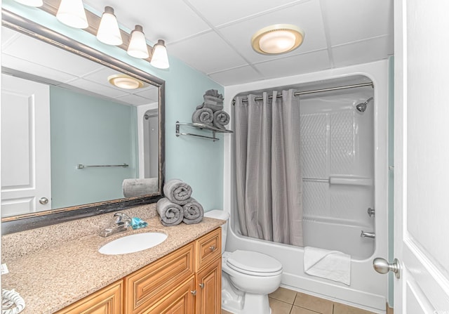 full bathroom featuring a drop ceiling, tile patterned flooring, toilet, shower / tub combo with curtain, and vanity