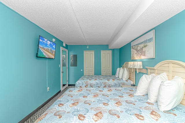 carpeted bedroom featuring a textured ceiling and two closets