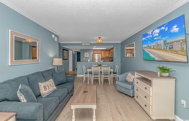 living room with a textured ceiling, light hardwood / wood-style flooring, and crown molding