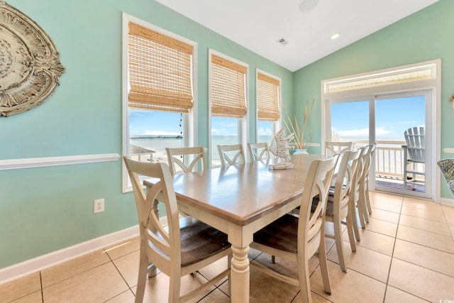 tiled dining room with a water view and lofted ceiling