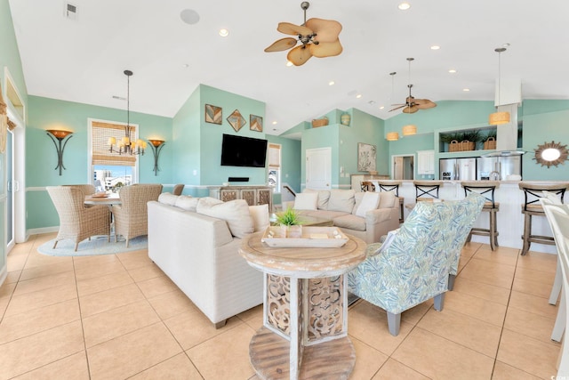 living room with light tile patterned floors, ceiling fan with notable chandelier, and vaulted ceiling