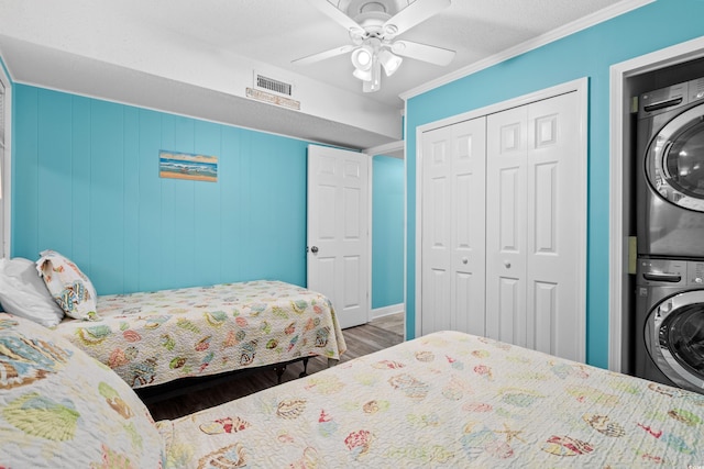 5601 N Ocean Blvd Unit C-305, Myrtle Beach, SC 29577 - bedroom featuring stacked washing machine and dryer, wood finished floors, a closet, crown molding, and a ceiling fan