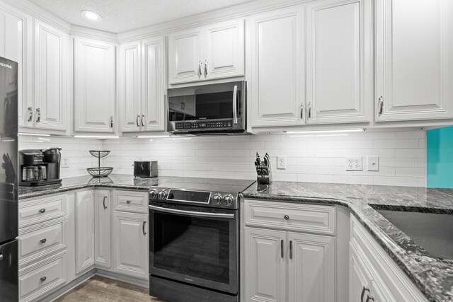 5601 N Ocean Blvd Unit C-305, Myrtle Beach, SC 29577 - kitchen with appliances with stainless steel finishes, white cabinets, backsplash, dark stone counters, and recessed lighting