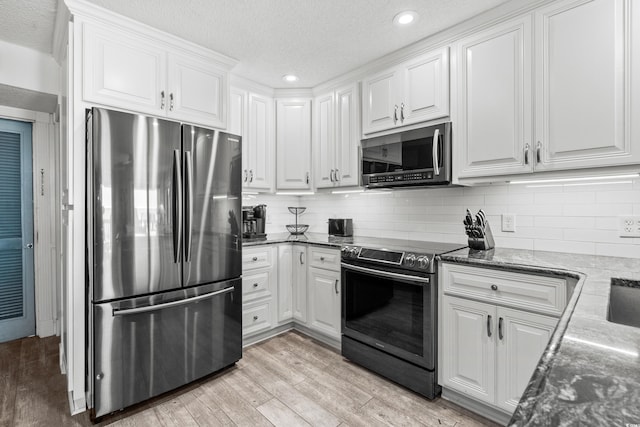 5601 N Ocean Blvd Unit C-305, Myrtle Beach, SC 29577 - kitchen featuring stainless steel appliances, white cabinets, dark stone countertops, light wood-type flooring, and recessed lighting