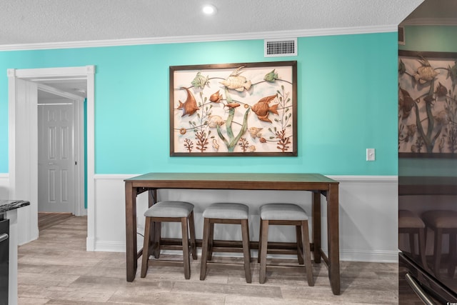 5601 N Ocean Blvd Unit C-305, Myrtle Beach, SC 29577 - dining area featuring a textured ceiling, wood finished floors, and ornamental molding