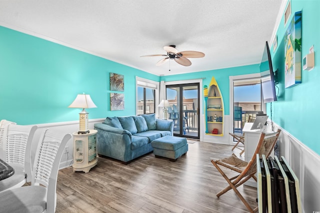 5601 N Ocean Blvd Unit C-305, Myrtle Beach, SC 29577 - living area with ceiling fan, a textured ceiling, a wainscoted wall, ornamental molding, and wood finished floors
