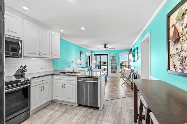 5601 N Ocean Blvd Unit C-305, Myrtle Beach, SC 29577 - kitchen featuring appliances with stainless steel finishes, a sink, a peninsula, light wood-style floors, and ornamental molding