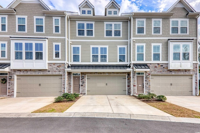 multi unit property featuring a garage, driveway, and stone siding