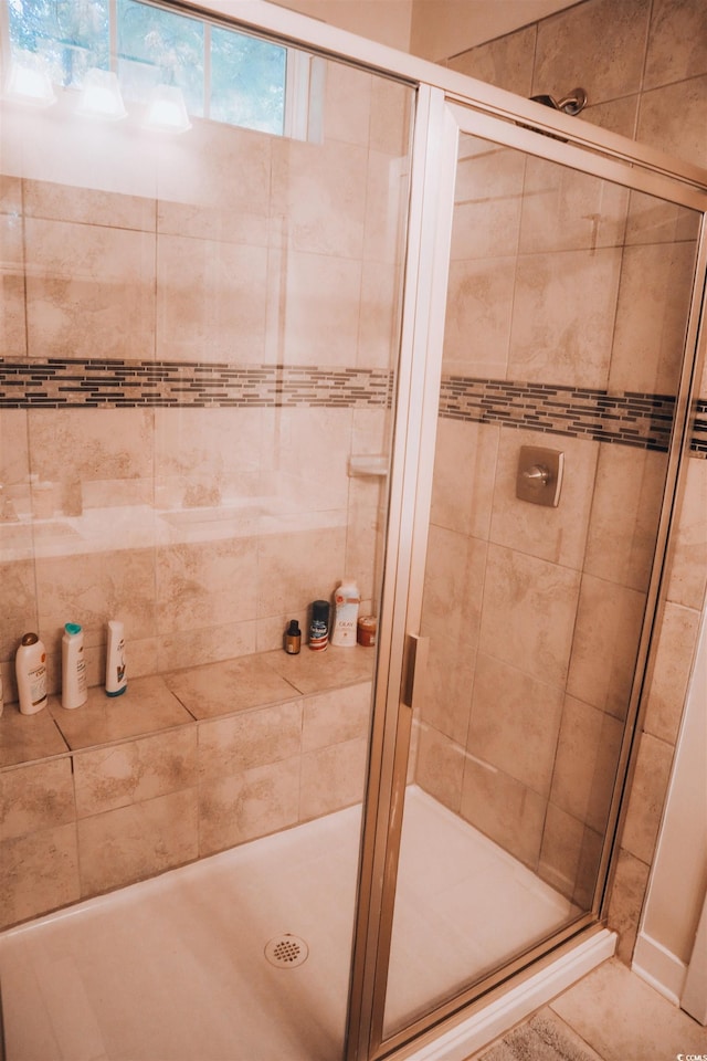 bathroom featuring tile patterned floors and a shower with shower door