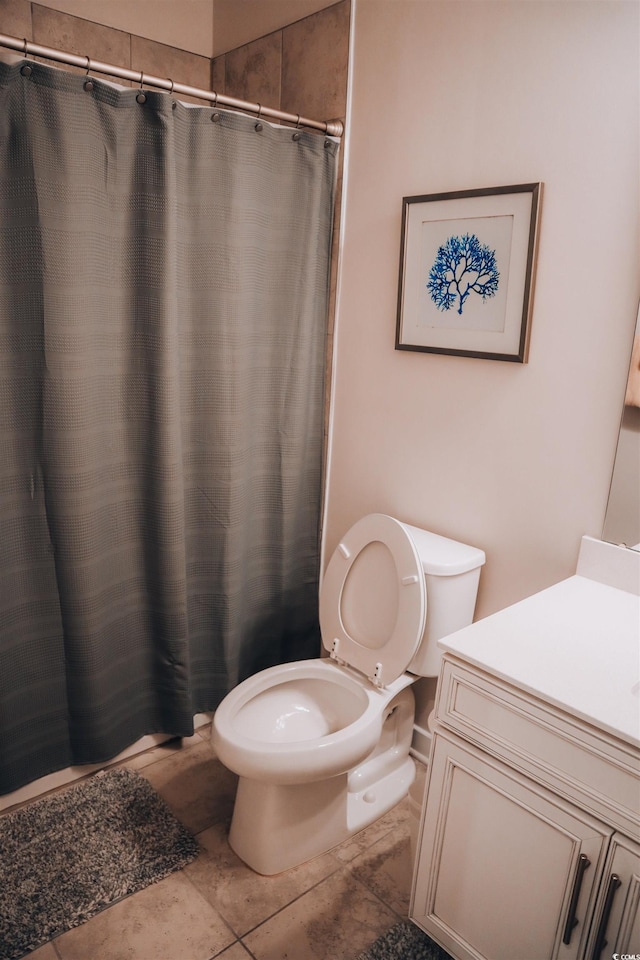 bathroom with a shower with shower curtain, tile patterned floors, vanity, and toilet