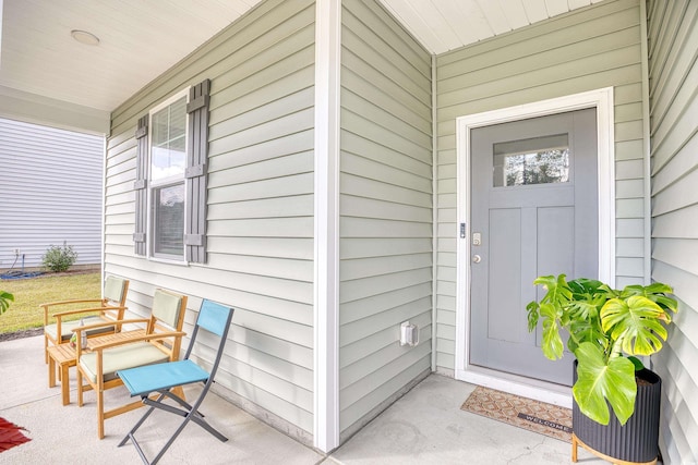 view of exterior entry featuring covered porch