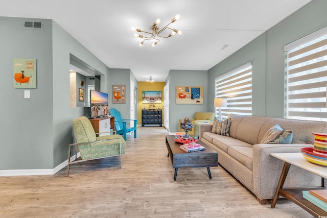 living room with an inviting chandelier and light hardwood / wood-style floors