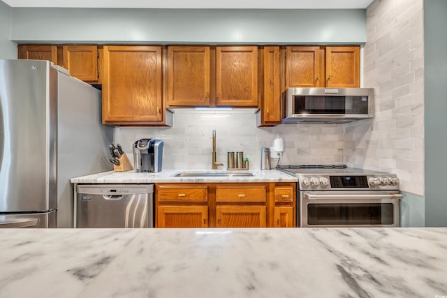 kitchen with sink, decorative backsplash, and appliances with stainless steel finishes