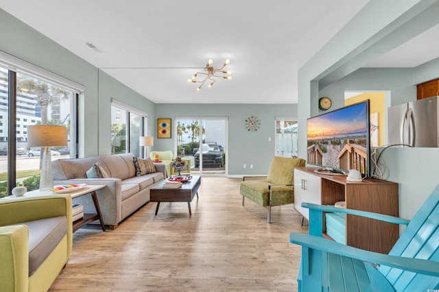 living room with light wood-type flooring and an inviting chandelier