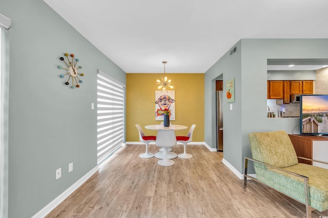 dining room with an inviting chandelier and light hardwood / wood-style flooring