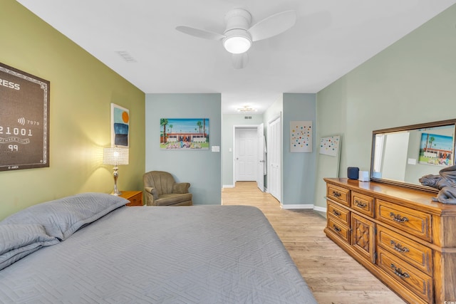 bedroom with light hardwood / wood-style floors, ceiling fan, and a closet